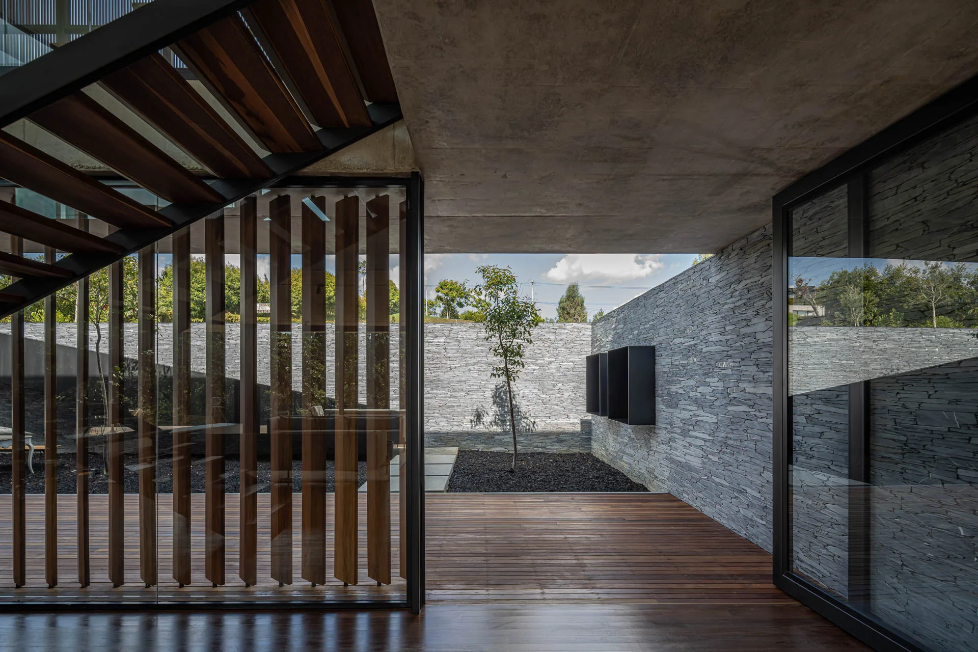 Fachada residencial moderna en concreto lavado y vidrio de Casa Balmoral 101 por Juan B. Echeverri.